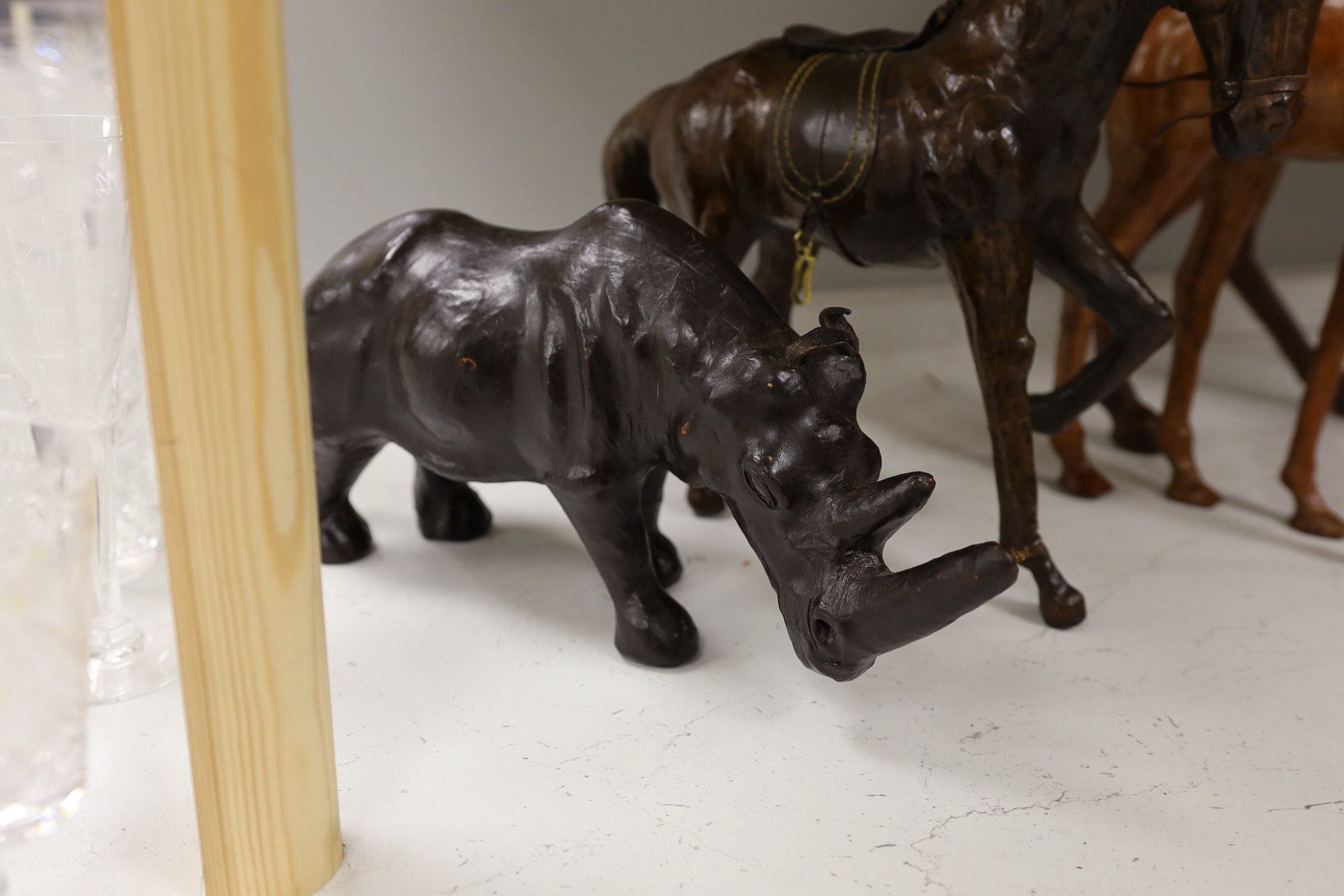 Two leather worked models of horses, a rhinoceros and a camel, tallest 42cm